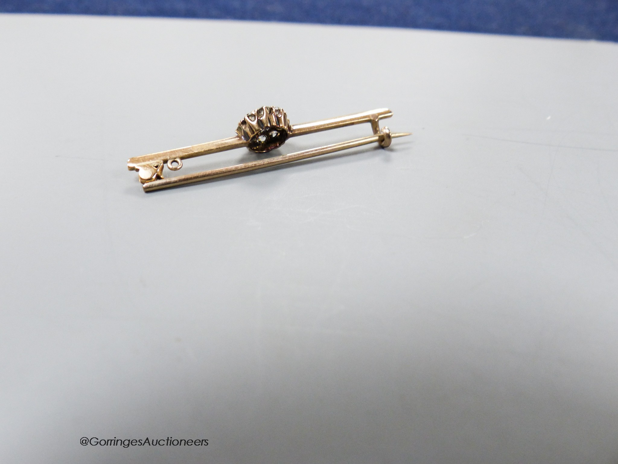 An early 20th century yellow metal and diamond cluster set bar brooch, 41mm, 2.2 grams.
